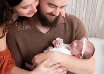 bébé nouveau-né posé dans les bras de ses parents lors d'une séance photo naissance à Béthune