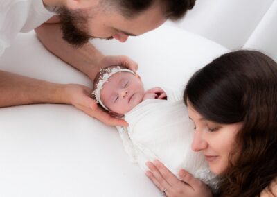 bébé nouveau-né dans les bras de ses parents lors d'une séance photo naissance en studio à Béthune